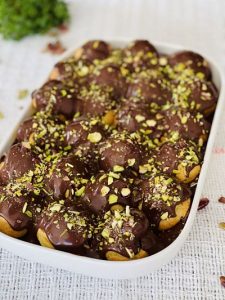 Choux a la creme la tavă cu cremă de fistic și zmeură, glasate cu ciocolată